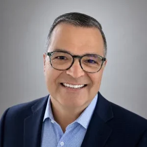A professional headshot of Chuck Hunter, the smiling founder of Hunter Travel